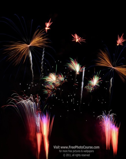 Picture of multiple fireworks with vibrant colors of orange, pink, red, green and gold.  Supporting article on How to Photograph Fireworks.© 2011, Stephen Kristof for FreePhotoCourse.com  